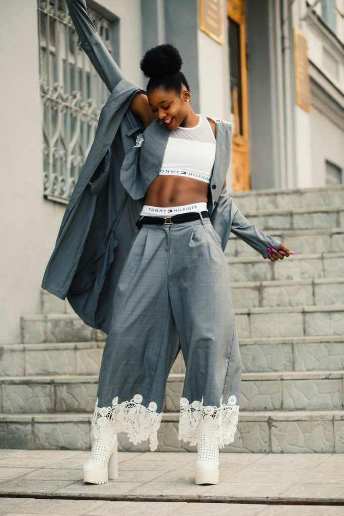 10 Unisex Colours You Can Wear 21 woman in gray blazer stands on gray concrete floor