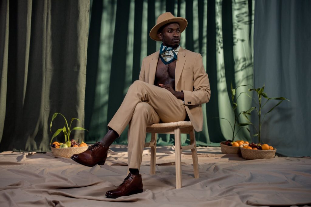 10 Unisex Colours You Can Wear 20 man in brown suit sitting on wooden chair while crossing his legs