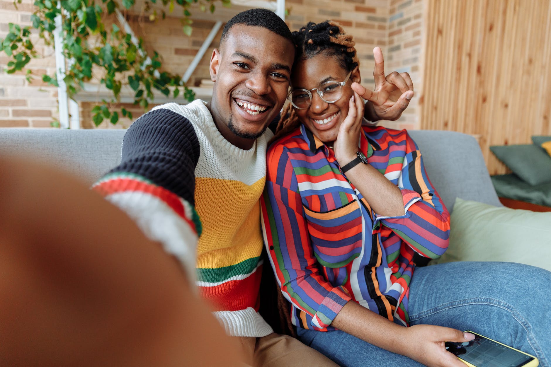 photo of a man in a knitted sweater taking a selfie with a woman