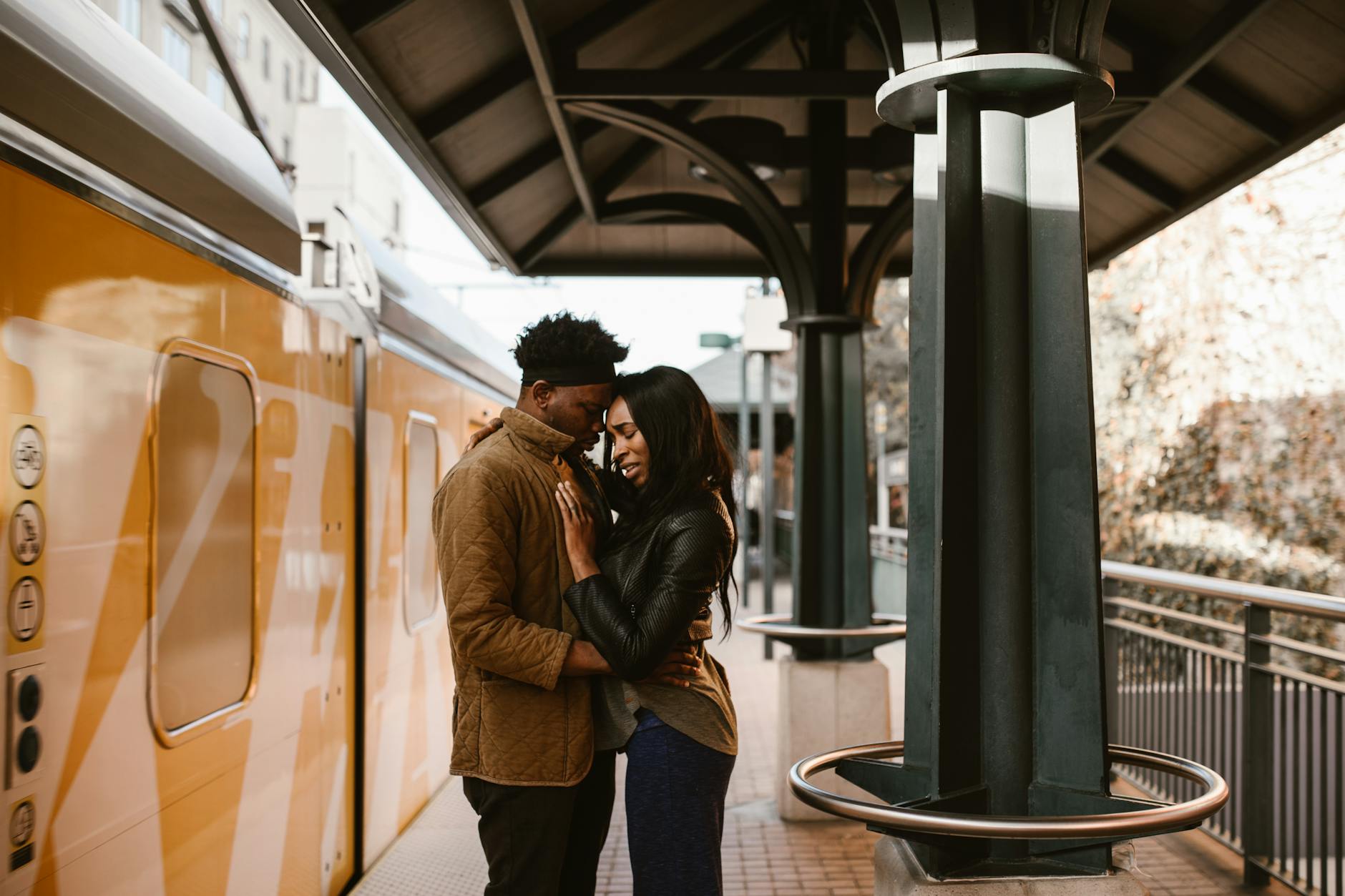 couple hugging beside orange train